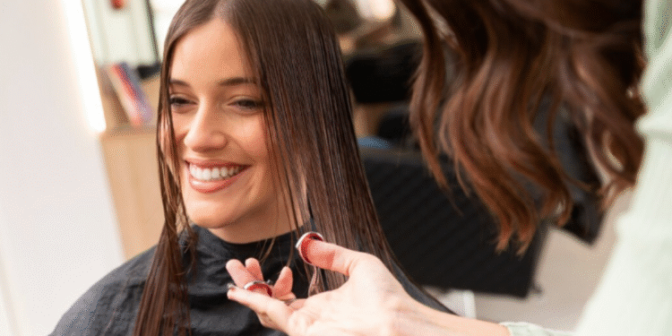 Mulher sorrindo enquanto corta o cabelo em salão de beleza moderno.