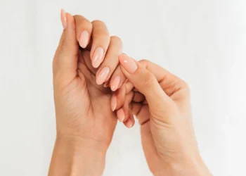 Unhas bem cuidadas com esmalte nude e formato arredondado