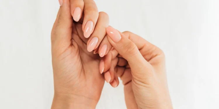 Unhas bem cuidadas com esmalte nude e formato arredondado