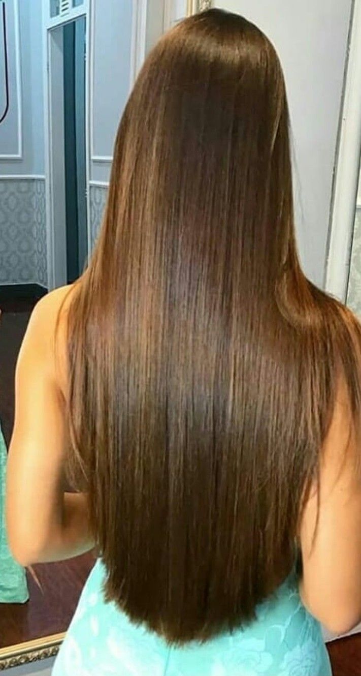 Mulher vista por trás com cabelo longo, liso e corte reto, em ambiente interno.