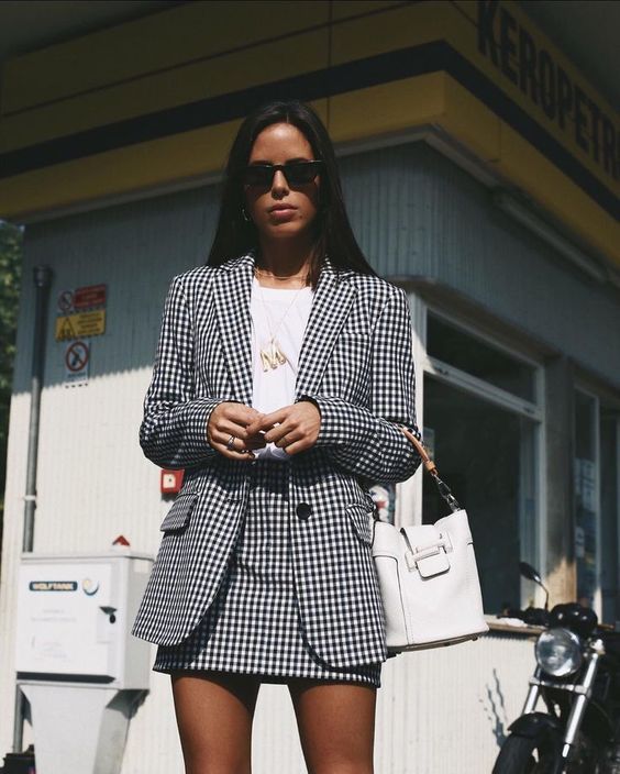 Mulher usando conjunto xadrez preto e branco com blazer e saia, ideal para look moderno de São João
