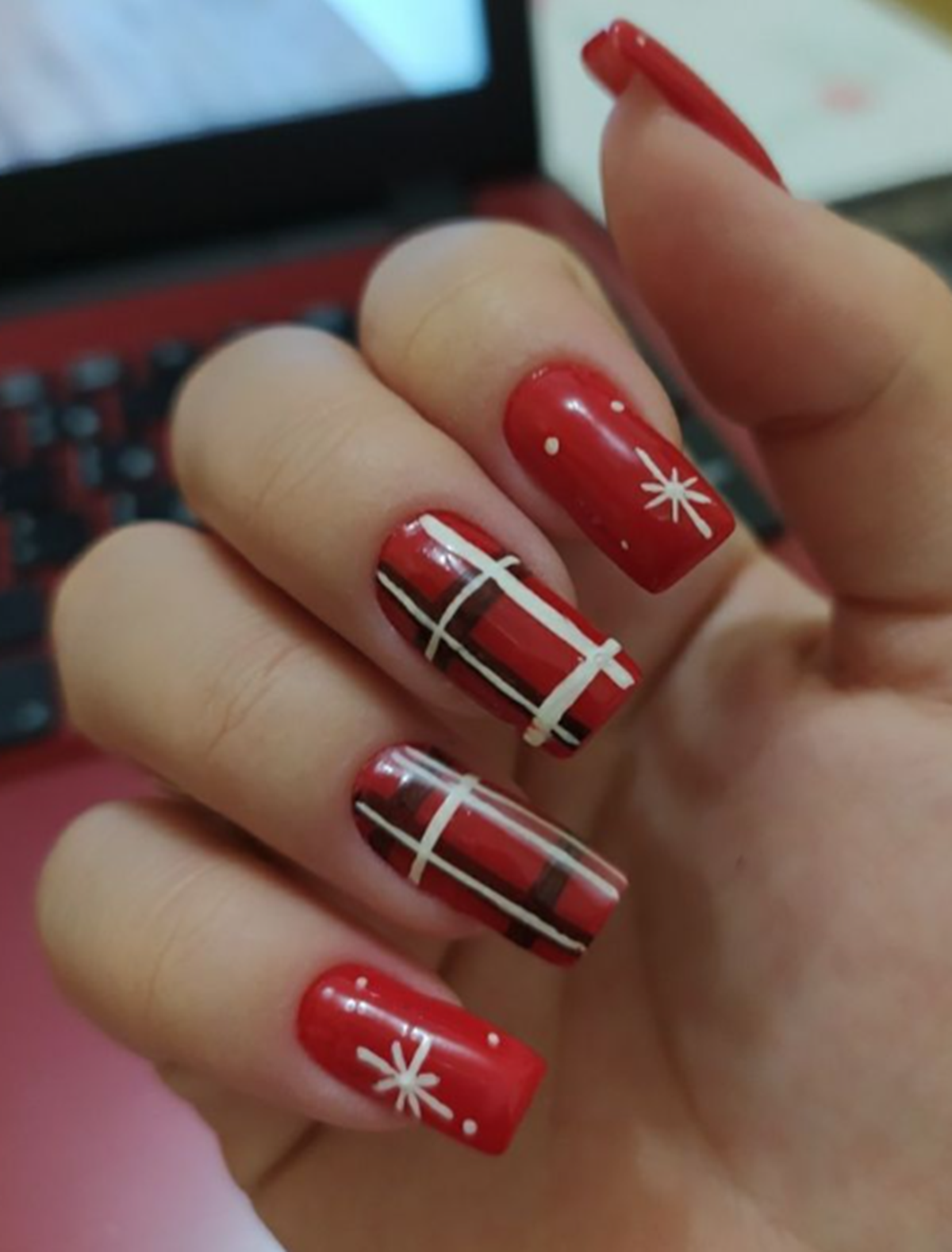 Unhas com estampa xadrez vermelha e preta, típica de festa junina.