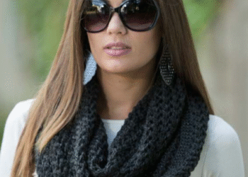 Mulher usando cachecol preto em ponto grosso, com estilo gola, para um visual elegante.