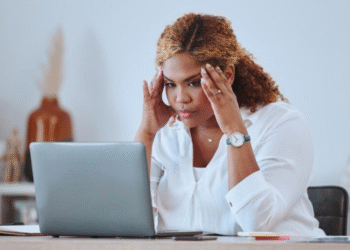 Mulher preocupada olhando para o notebook em ambiente de trabalho