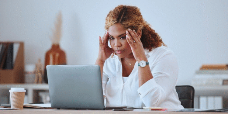 Mulher preocupada olhando para o notebook em ambiente de trabalho
