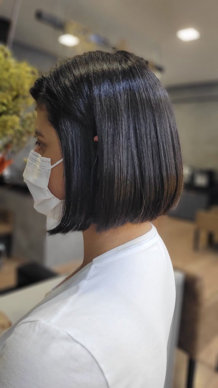 Corte de cabelo chanel clássico reto em mulher com fios escuros e lisos