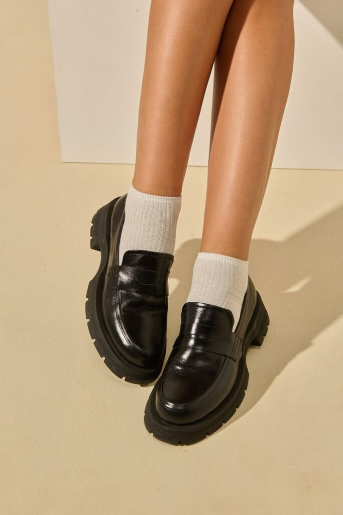 Mocassim preto de couro com sola grossa, ideal para um look elegante e confortável.