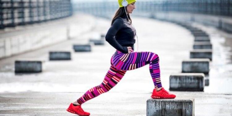 Exercício físico no Inverno: dicas para se manter ativa e saudável 1 Mulher praticando exercício físico ao ar livre durante o inverno com roupas coloridas e touca.