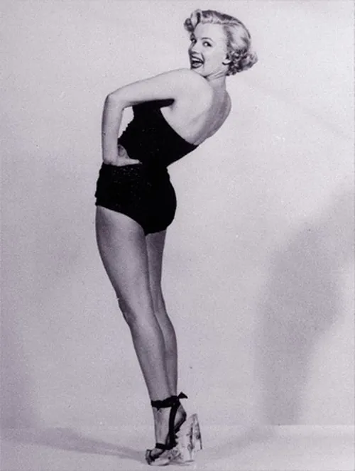 Marilyn Monroe posando com salto alto, símbolo de sensualidade e poder feminino.