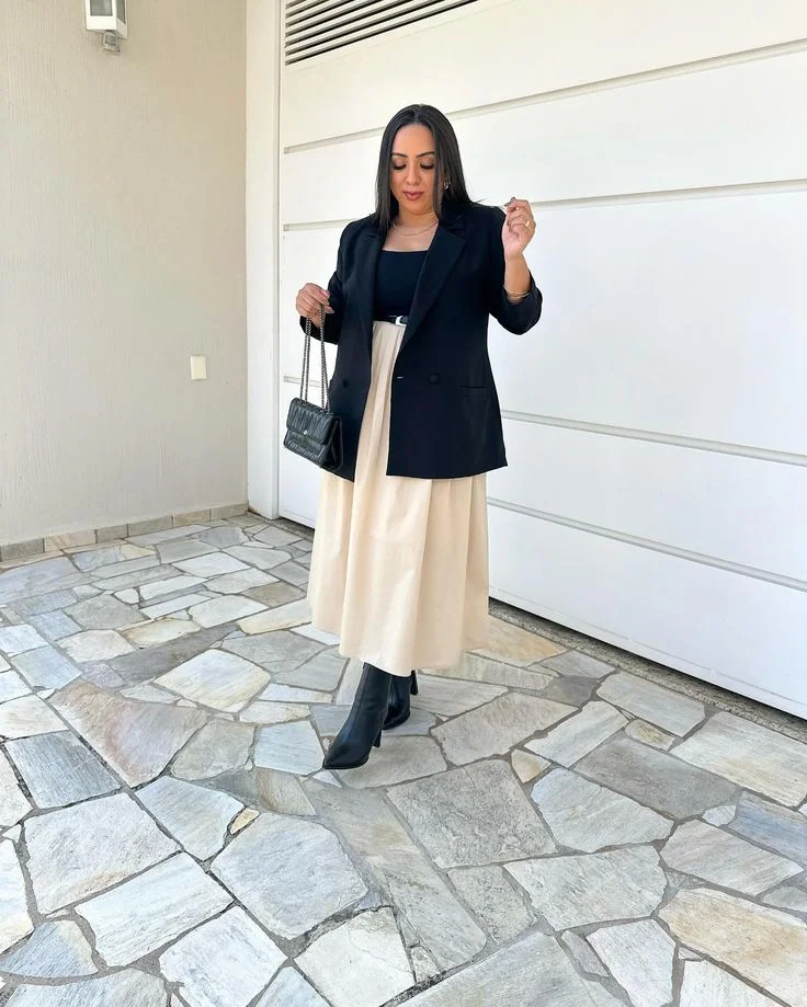 Look elegante com saia godê e blazer, combinando estilo clássico e moderno.