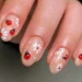 Unhas decoradas com ladybugs e flores brancas para arrasar no fim de semana.