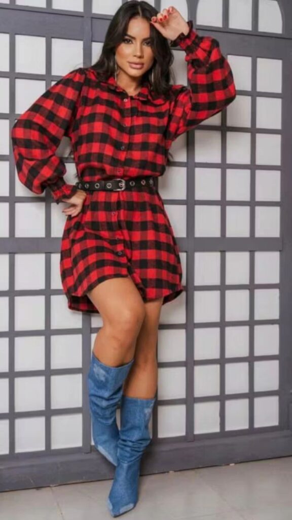Mulher usando vestido xadrez vermelho e preto com cinto e bota jeans, look moderno para festa junina