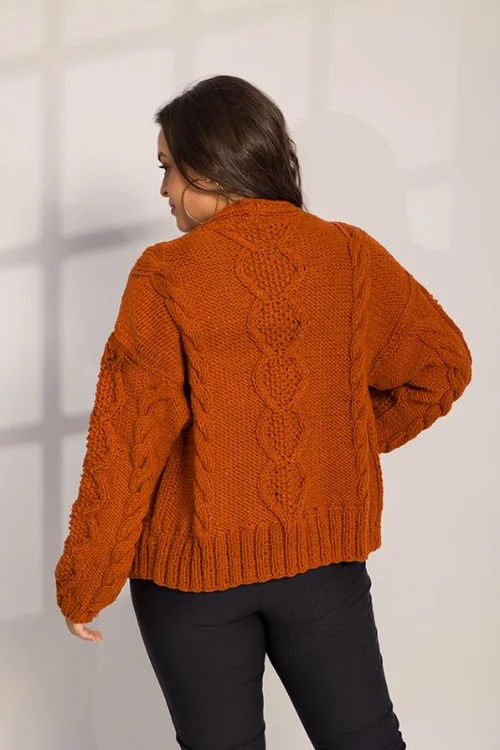Mulher de costas usando um cardigan de tricô laranja com textura marcada, em um fundo claro e suave.