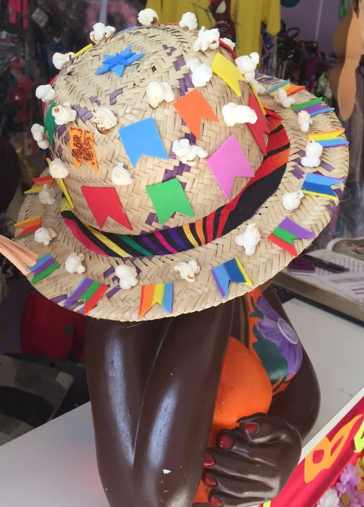 Chapéu de palha decorado com pipoca e bandeirinhas coloridas para festa junina