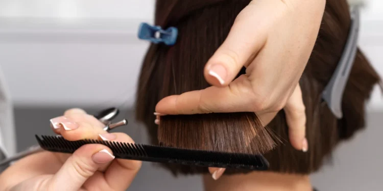 Profissional realizando corte bob com técnica precisa para renovação do visual