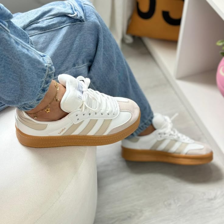 Tênis casual branco com detalhes em bege e sola de borracha, usado com calça jeans.