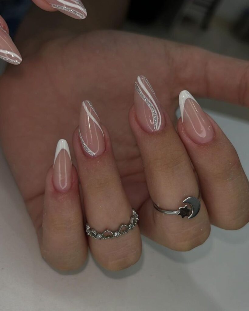 Unhas de gel em formato amendoado com francesinha moderna e traços brilhantes
