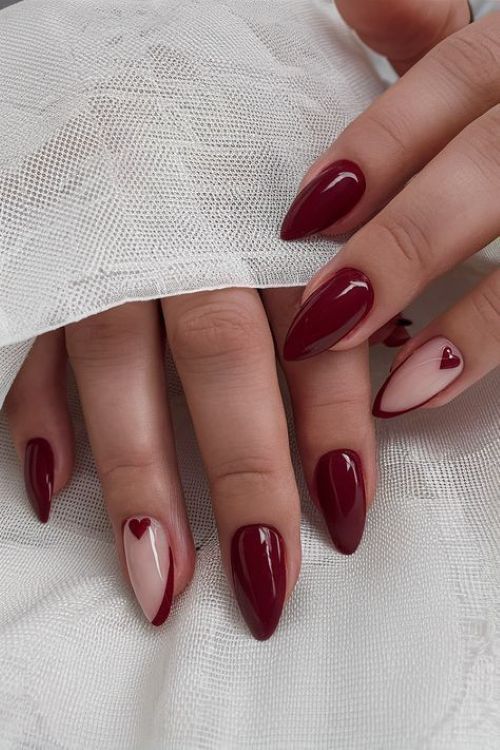 Unhas decoradas em tom vinho com detalhe de coração minimalista