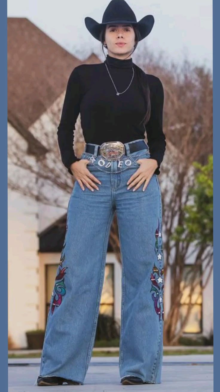 Mulher usando look estilo western com chapéu, blusa preta e calça jeans bordada com cinto de fivela grande