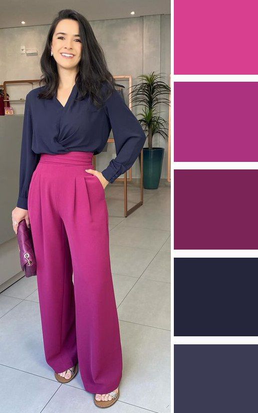 Mulher sorrindo usando uma combinação de cores roxa e magenta, com blusa azul escura e calça magenta, acompanhada de acessórios em tons complementares.