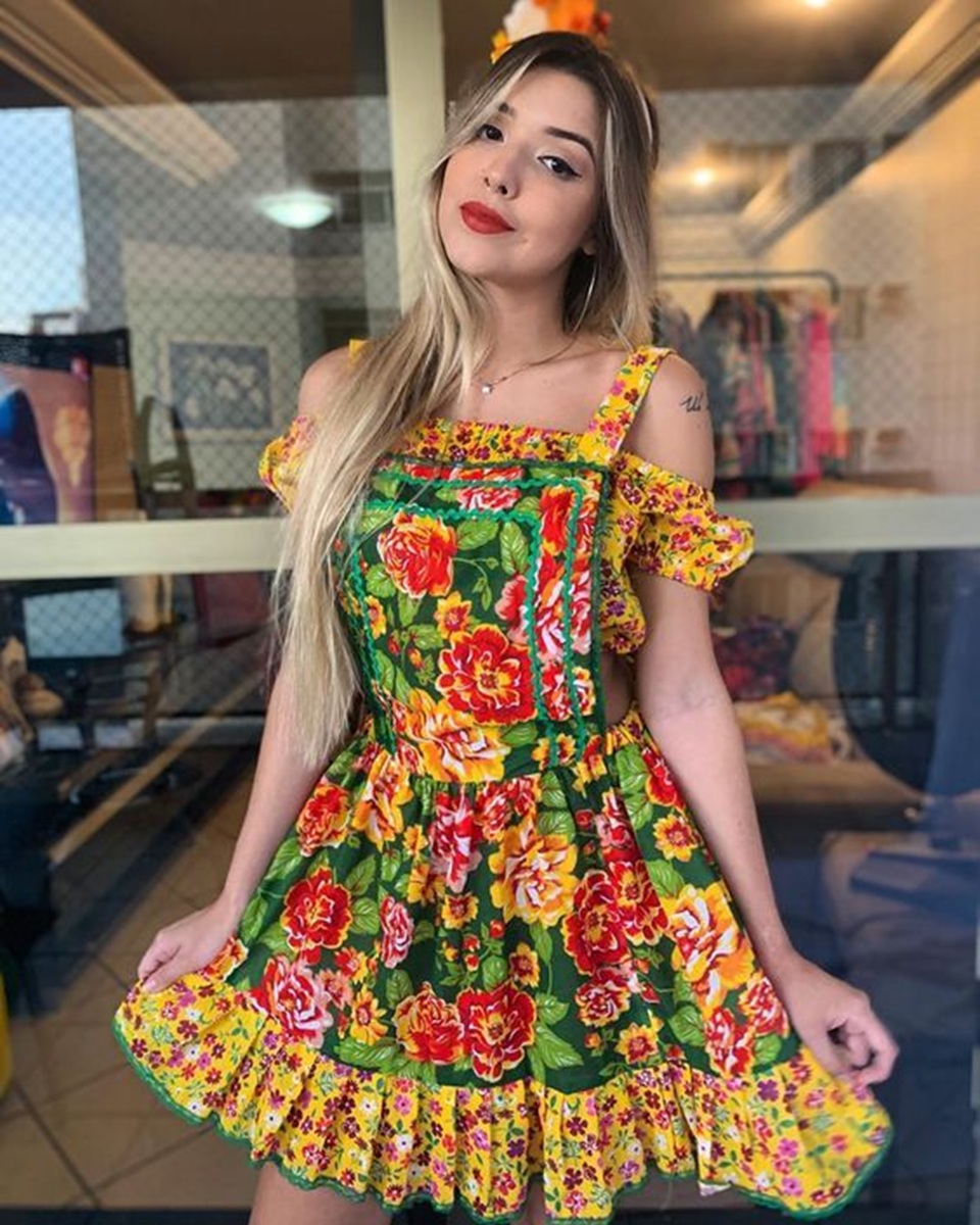 Mulher usando vestido estampado colorido, look romântico e floral.