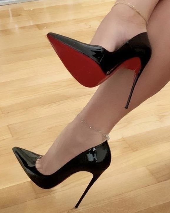 Scarpin preto de bico fino e salto alto, com sola vermelha, um ícone de elegância e estilo.