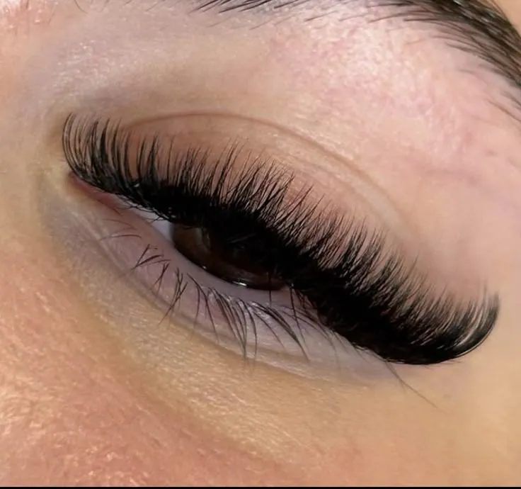 Visão detalhada de extensões de cílios aplicadas, mostrando o efeito volumoso e natural.