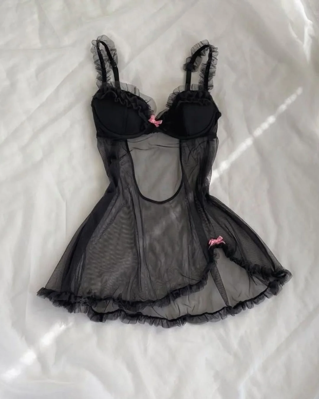 Lingerie delicada com detalhes em tule preto e laços rosa.