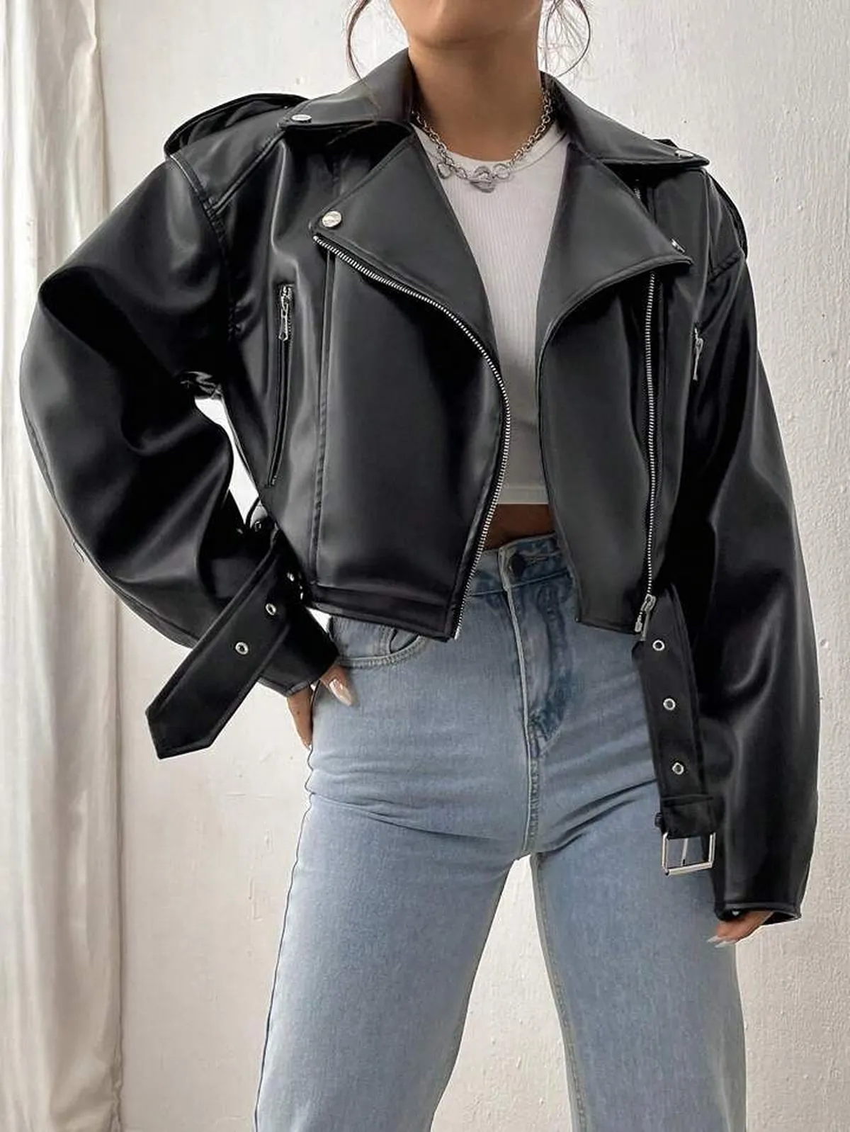 Mulher usando jaqueta de couro preta com calça jeans de cintura alta
