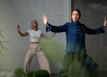 Mulheres praticando Tai Chi em um ambiente moderno, realizando movimentos suaves que fortalecem corpo e mente.