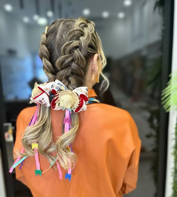 Trança dupla com minichapéu de palha e laços coloridos, ideal para festas juninas.