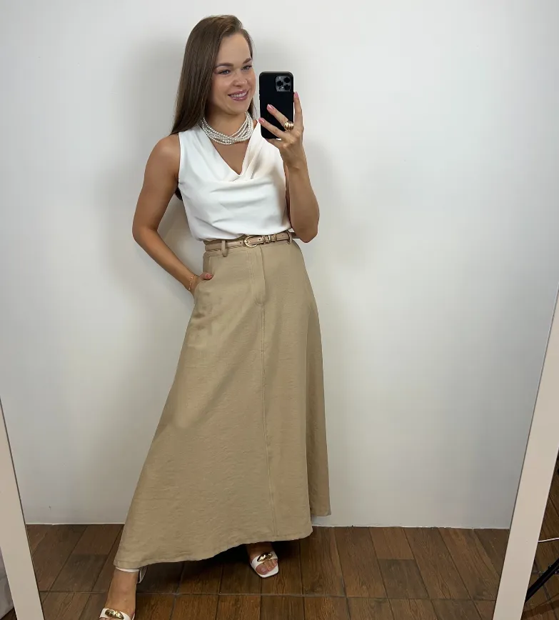 Look elegante com saia godê e camisa de seda, acessórios refinados e estilo sofisticado.