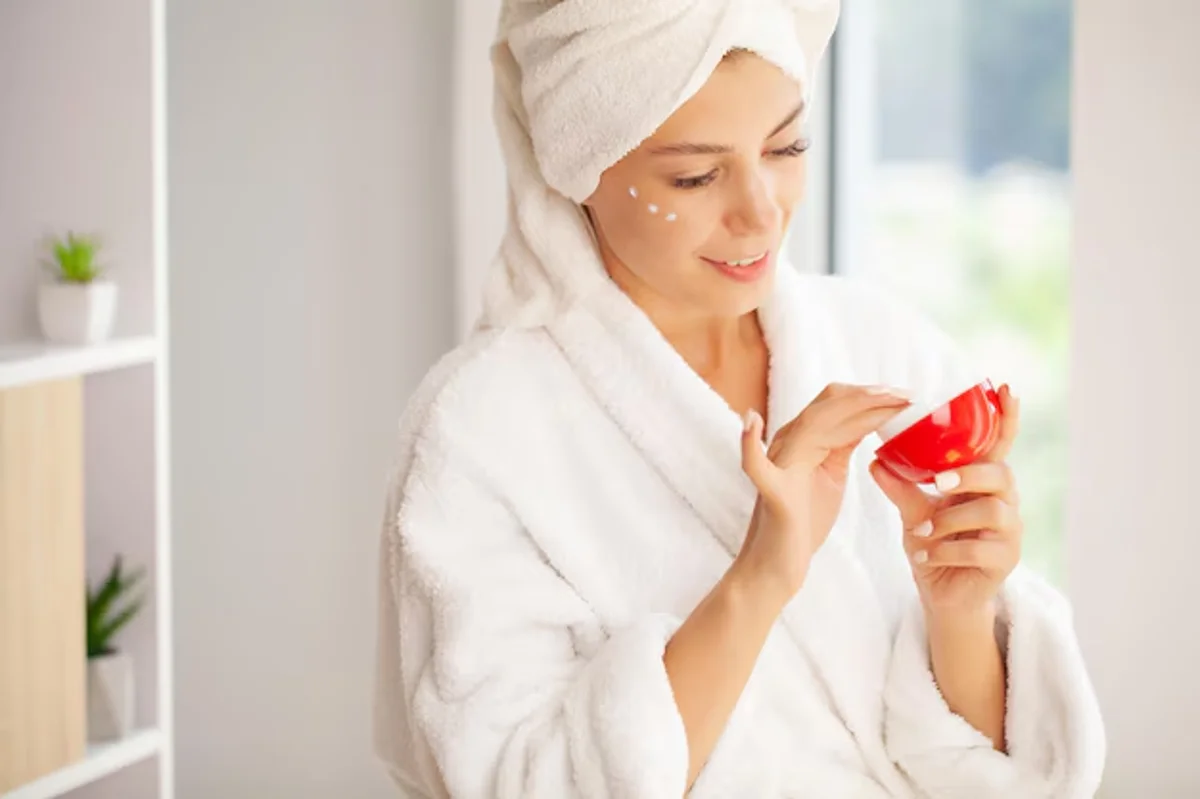 Mulher aplicando creme facial como parte de sua rotina de skincare