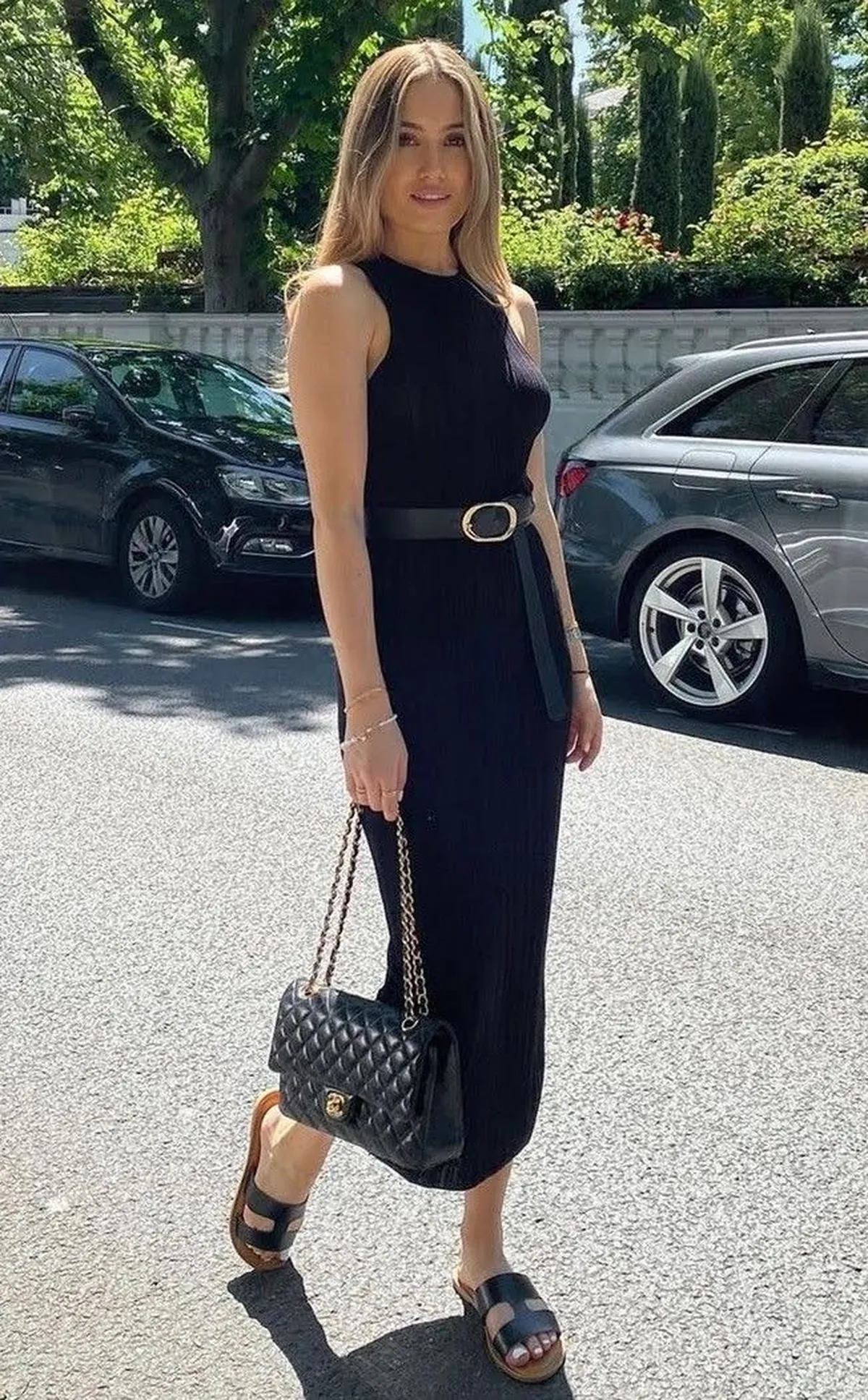 Mulher usando vestido preto básico e acessórios neutros