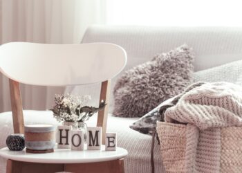 Ambiente de sala de estar limpo e organizado com letras 'HOME', transmitindo conforto e a sensação de casa arrumada.