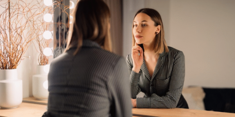 Dicas de moda que vão transformar seu estilo hoje! 1 Mulher se olhando no espelho enquanto avalia seu visual.