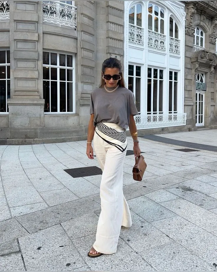 Lenço amarrado na cintura com calça de tecido leve, criando um look sofisticado.