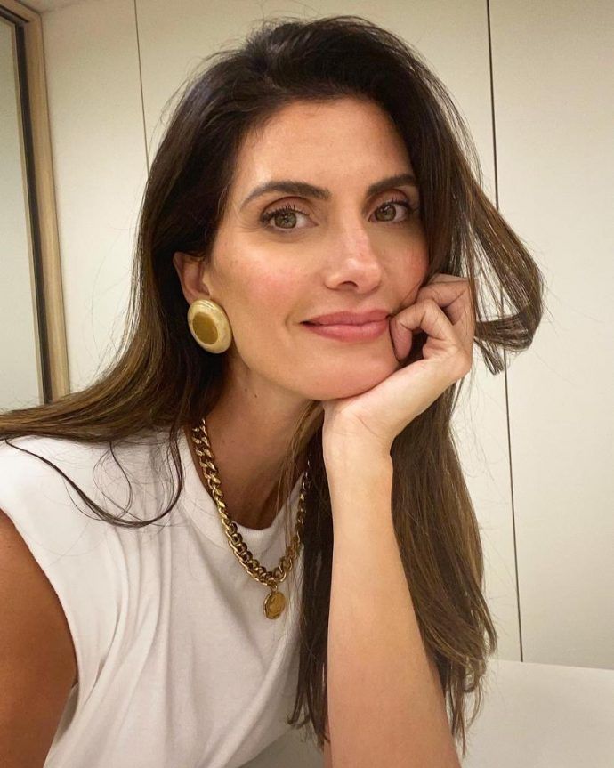 Mulher com acessórios dourados que elevam um look básico