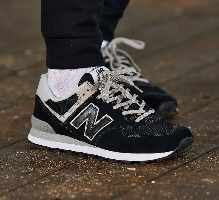 Tênis New Balance 574 em estilo streetwear, combinando com roupas urbanas.