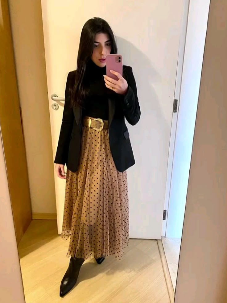 Look de inverno com blazer preto, saia midi de poá e bota preta.