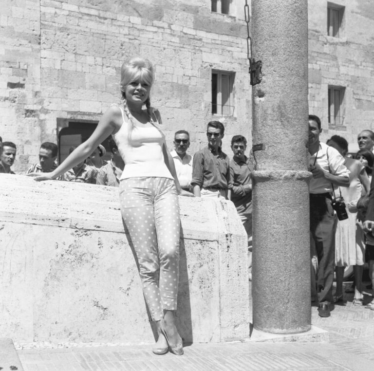Brigitte Bardot usando calça capri e sapatilhas durante as férias na Itália nos anos 1960, estilo atemporal.
