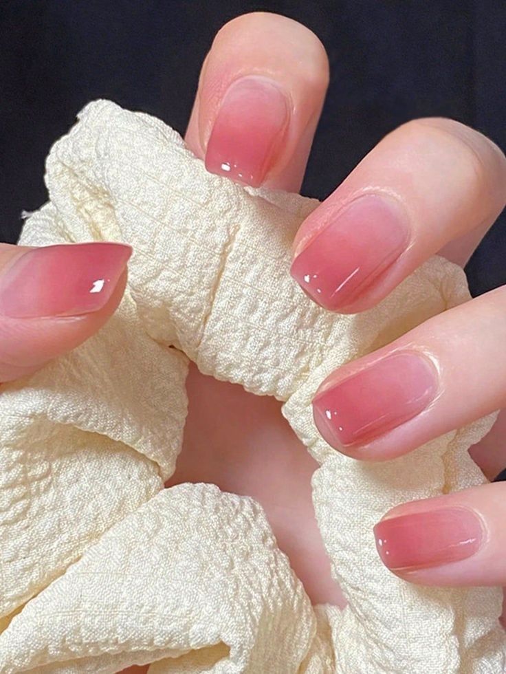 Unhas com esmalte rosado translúcido estilo jelly e acabamento brilhante