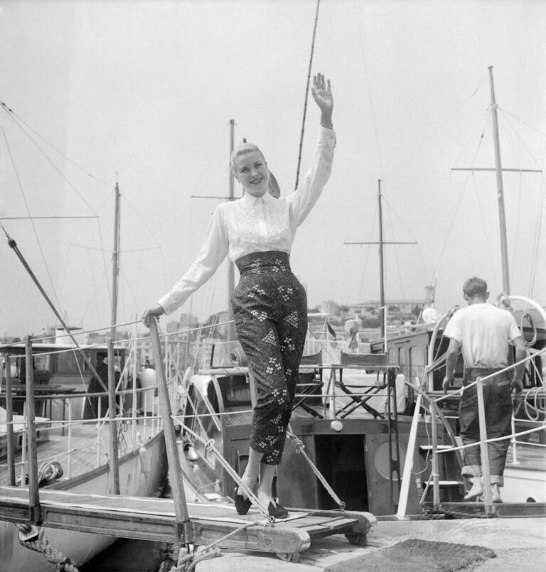 Grace Kelly usando calça capri florida chegando ao Festival de Cinema de Cannes em 1955, um dia antes de conhecer o Príncipe Rainier de Mônaco.