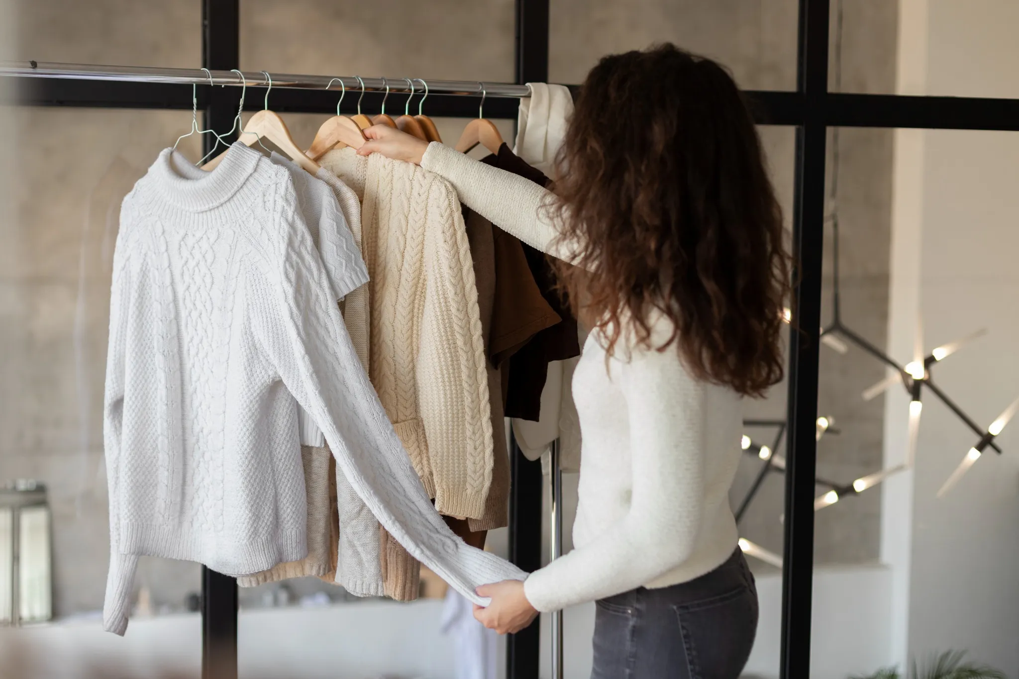 Mulher organizando e selecionando roupas do guarda-roupa para facilitar a rotina diária.