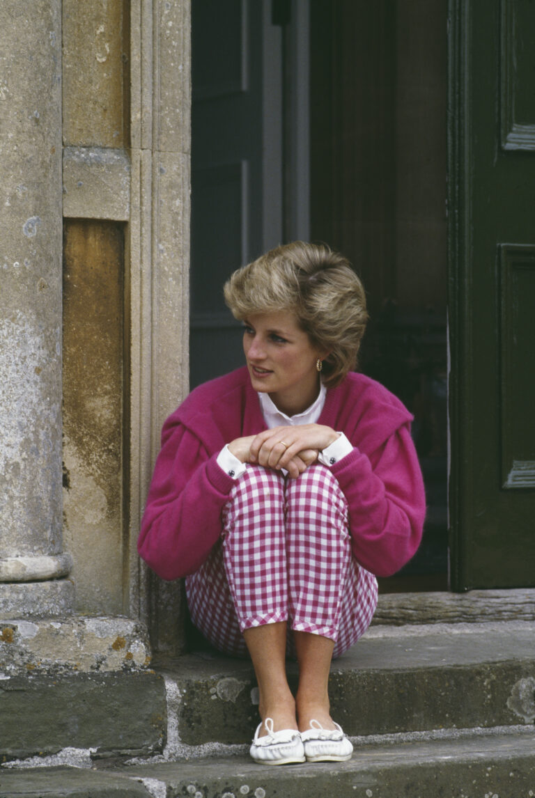 Princesa Diana em 1986 usando suéter pink e calça capri quadriculada, completando o look com mocassim branco.