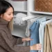 10 peças essenciais que toda mulher estilosa precisa no guarda-roupa 15 Mulher organizando calças em seu guarda-roupa de forma prática e estilosa