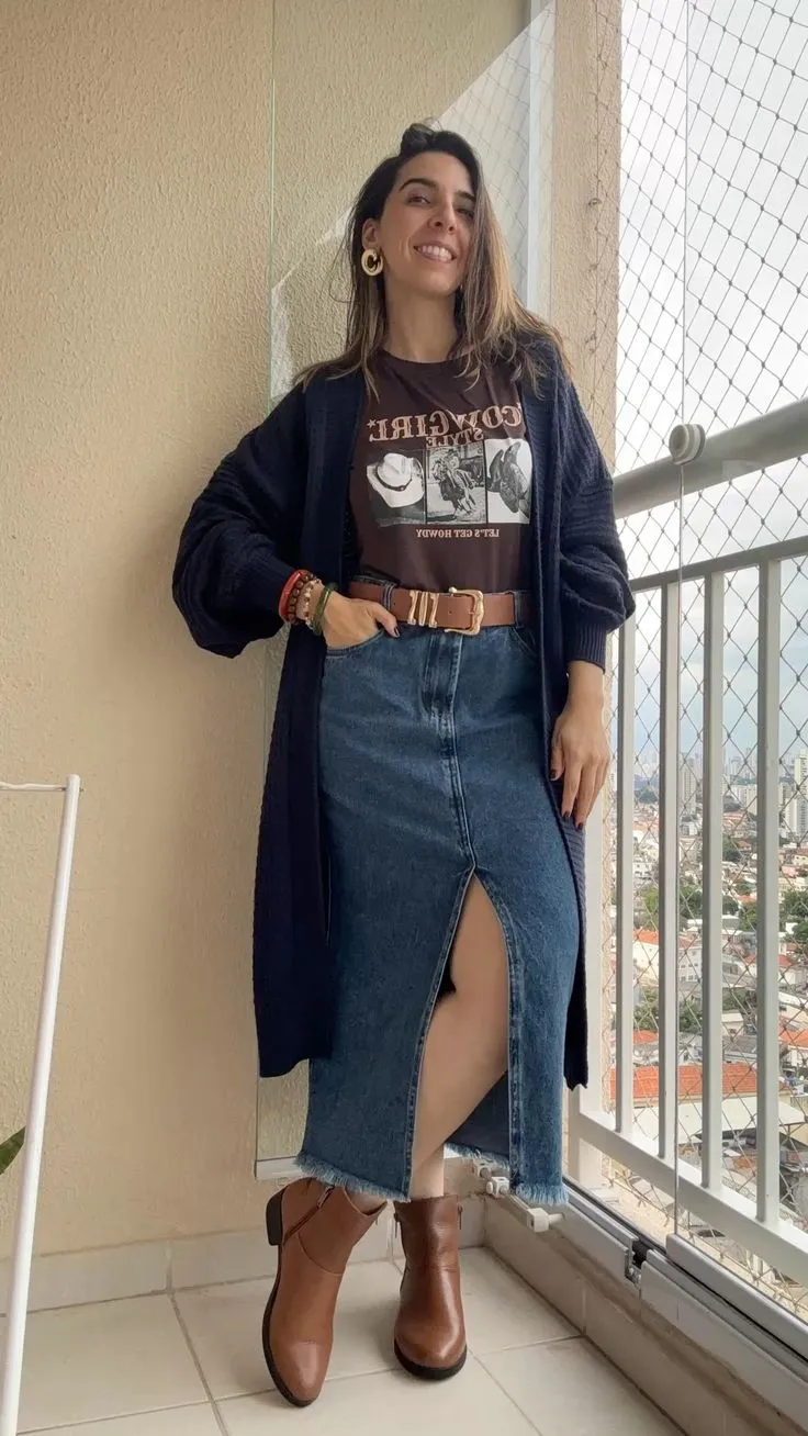 Mulher usando saia midi de jeans com fenda e botas, mostrando um estilo moderno e casual.