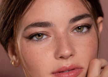 Retrato de uma jovem mulher com maquiagem suave e expressão tranquila.