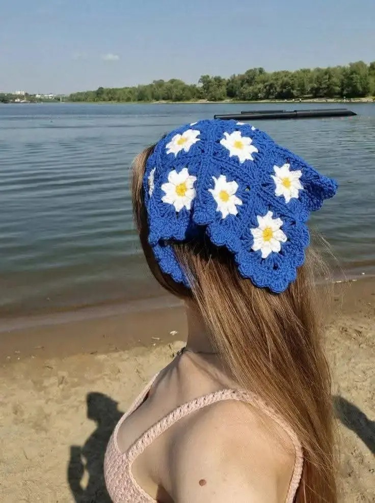 Bandana de crochê azul com flores brancas, ideal para o verão 2026, com vista para o lago.