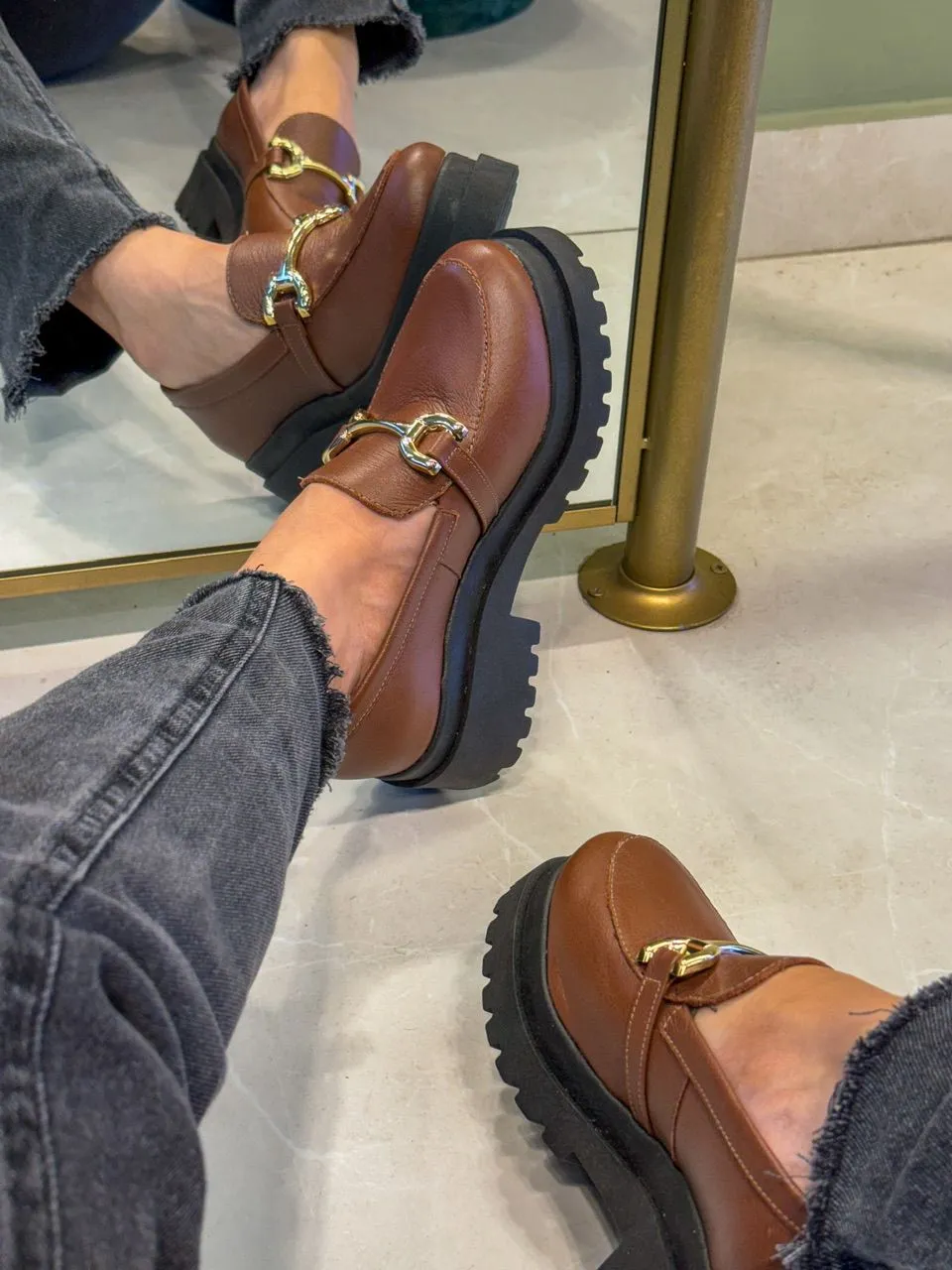 Mocassins modernos de couro marrom com corrente dourada e sola tratorada